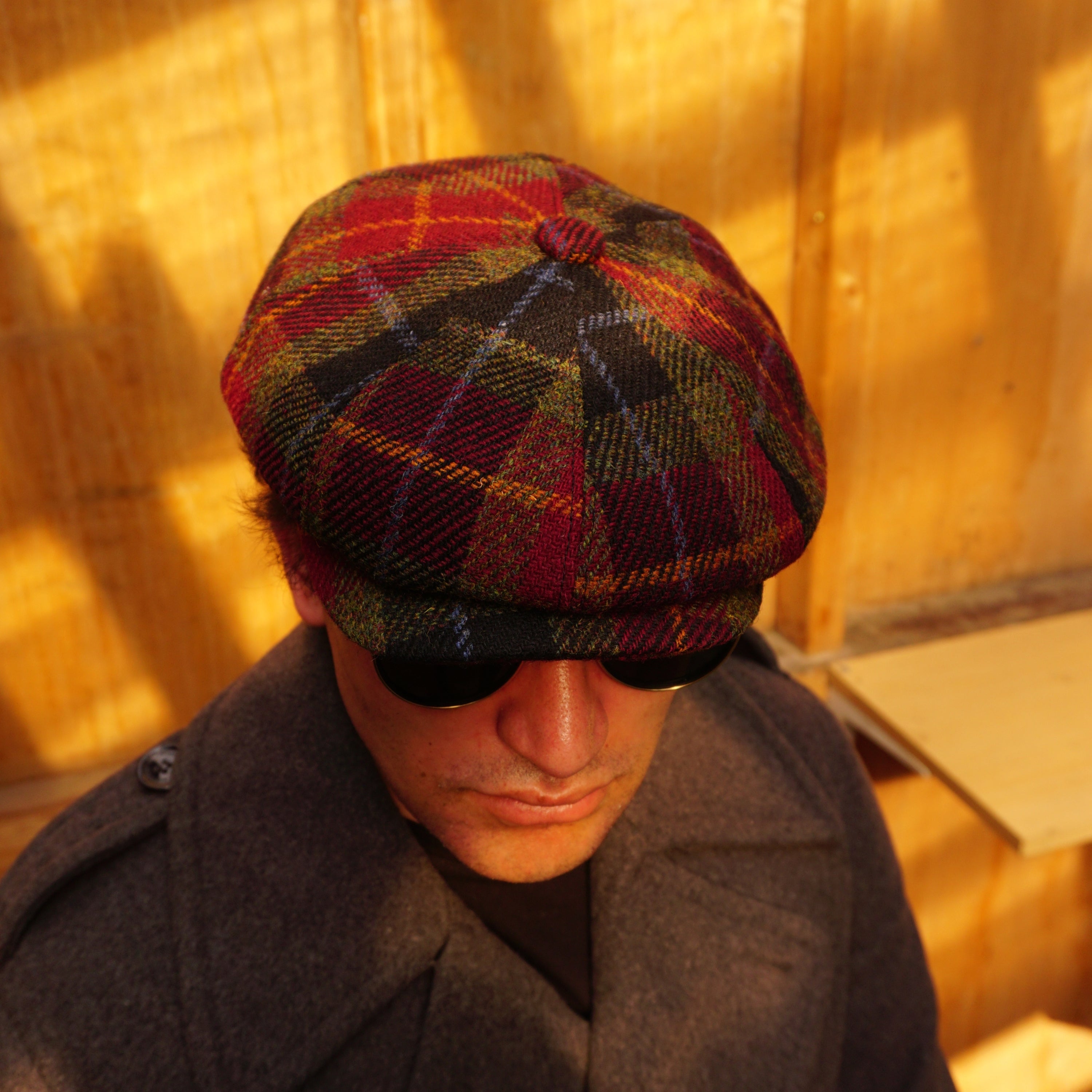 Burgundy Harris Tweed Newsboy Cap, crafted from 100% pure new wool, handwoven in Scotland’s Outer Hebrides. Features include a sewn-down brim, cotton lining, and a removable Gladwin Bond side pin. Available in sizes S-XXL. Inspired by the iconic Peaky Blinders style.